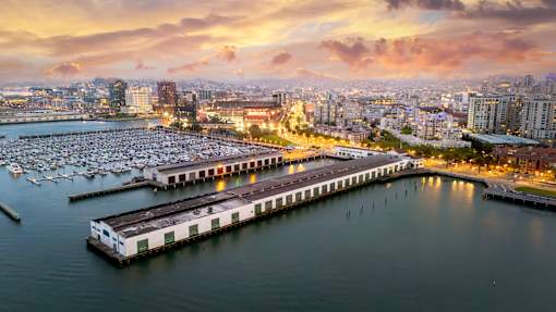 A marina filled with lots of boats at sunset.