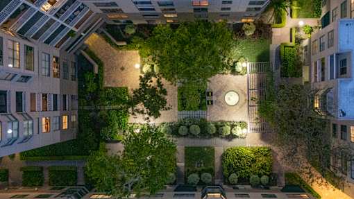 A courtyard surrounded by buildings with a clock on the wall.