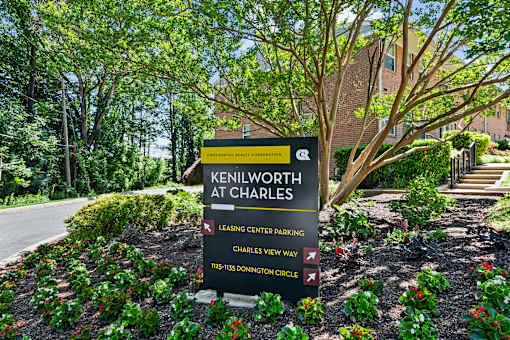 A sign for Kenilworth at Charles is displayed in front of a landscaped area.