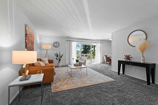 A living room with a grey carpet and a brown sofa.