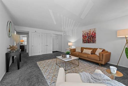 A living room with a couch, a coffee table, and a rug.