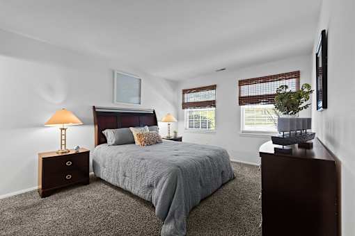 A bedroom with a bed, nightstand, and lamp.
