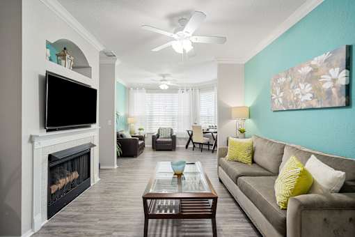 A living room with a fireplace and a couch at The Grand Reserve at Tampa Palms Apartments, Florida, 33647