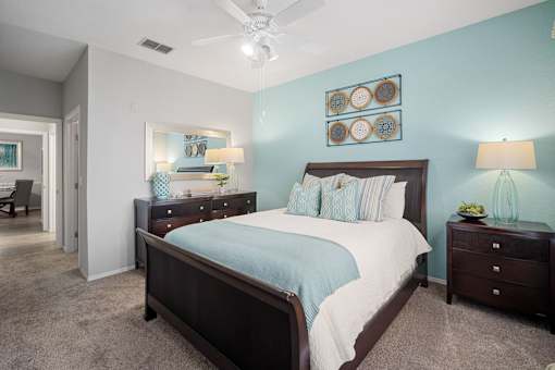 A bedroom with a bed, nightstands, and a ceiling fan at The Grand Reserve at Tampa Palms Apartments, Tampa, FL, 33647
