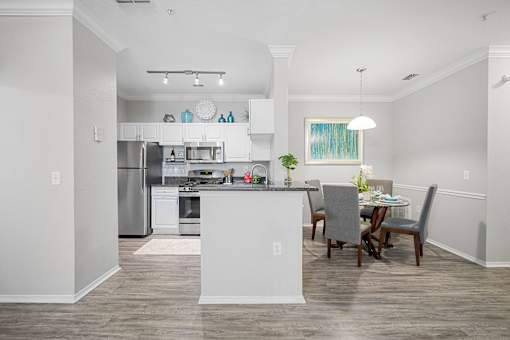 A modern kitchen with a dining table and chairs at The Grand Reserve at Tampa Palms Apartments, Florida, 33647
