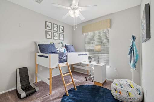 A room with a bunk bed and a chair at The Grand Reserve at Tampa Palms Apartments, Tampa, Florida