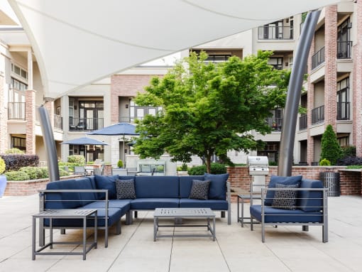 Outdoor sectional sofa seating under canopy at St. Marys Square Apartments, North Carolina