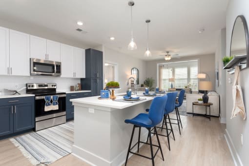 an open kitchen with an island and blue bar stools at Bristol at New Riverside, Bluffton
