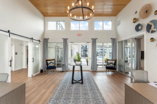 Leasing office with a circular chandelier and sliding glass doors at Bristol at New Riverside, Bluffton, 29910