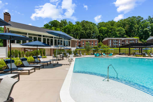 resort style swimming pool with apartments and community center in the background at Padonia Village Apartments, 21093