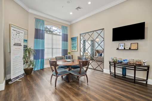 A living room with a wooden floor and a dining table with chairs at The Grand Reserve at Tampa Palms Apartments, Tampa, Florida