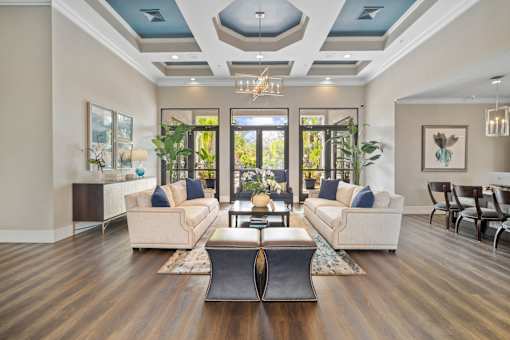 A modern living room with a large window and a wooden floor at The Grand Reserve at Tampa Palms Apartments, Tampa, FL