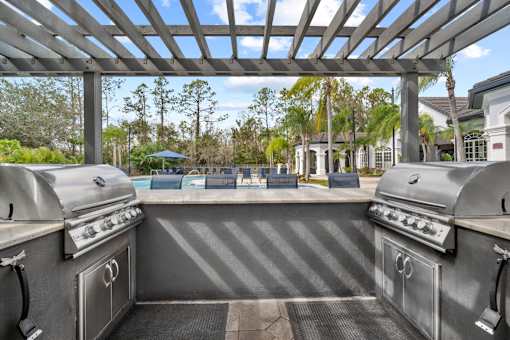 pergola with two grills overlooking pool at The Grand Reserve at Tampa Palms Apartments, Florida