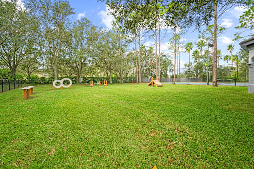 A park with a grassy area and a large sculpture in the middle at The Grand Reserve at Tampa Palms Apartments, Florida
