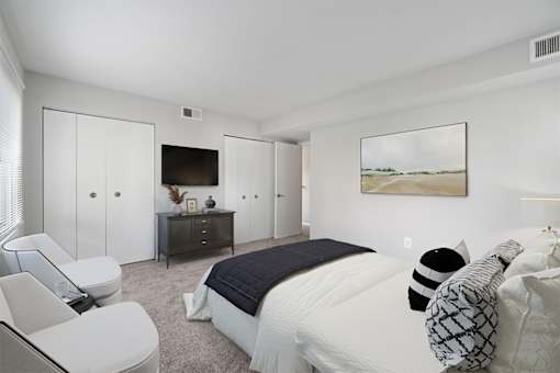 a bedroom with a large bed and a tv on the wall at Falls Village Apartments, Baltimore MD