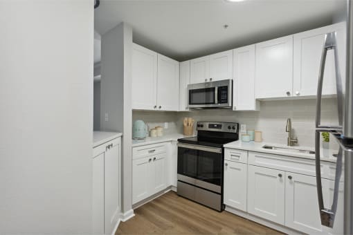 a kitchen with white cabinets and stainless steel appliances at The Bluestone Apartments, Bluffton, 29910
