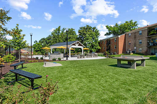 a park with picnic tables and a gazebo in front of a building at Courthouse Square Apartments, Towson, MD, 21286