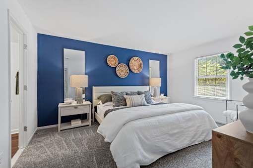 a bedroom with a bed and a blue wall at Courthouse Square Apartments, Towson, MD