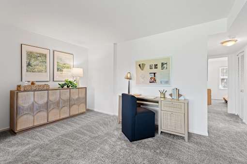 a living room with a blue chair and a desk at Courthouse Square Apartments, Maryland, 21286