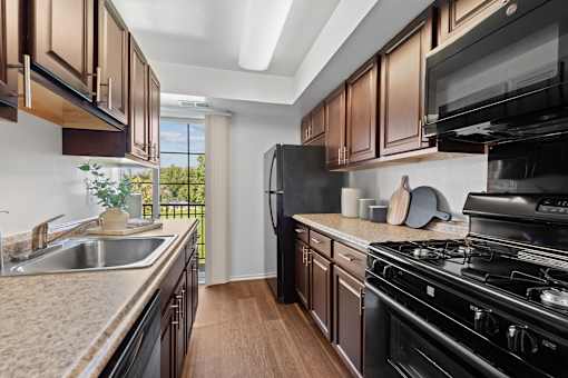 a kitchen with granite counter tops and black appliances at Courthouse Square Apartments, Towson, MD, 21286