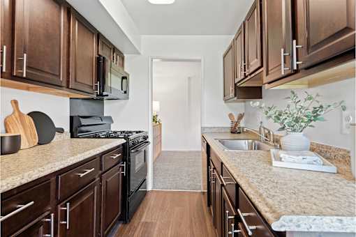 a kitchen with wooden cabinets and granite counter tops at Courthouse Square Apartments, Towson, 21286
