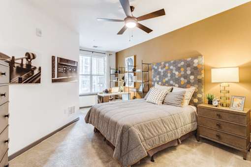 a bedroom with a bed and a ceiling fan at Dartmoor Place at Oxford Square Apartments, Hanover