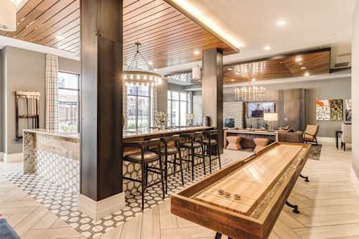 Community room with shuffleboard table  at Dartmoor Place at Oxford Square Apartments, Maryland