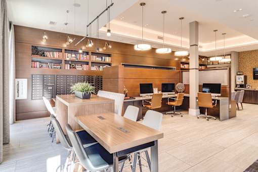 a large community room  with a table and chairs and a desk at Dartmoor Place at Oxford Square Apartments, Hanover, 21076