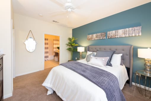 a bedroom with a large bed and a blue accent wall at Fortress Grove, Murfreesboro