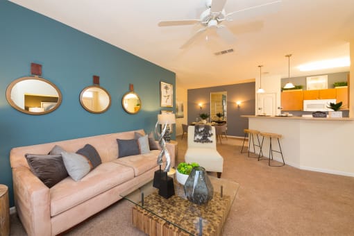 a living room with a blue accent wall and a tan couch at Fortress Grove, Murfreesboro, Tennessee