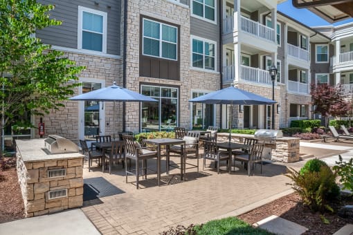 Grilling area with outdoor dining seating  at The Flats at Ballantyne Apartments, North Carolina, 28277
