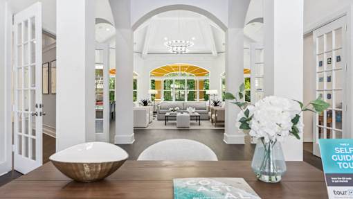 resident lounge with a table and a vase of flowers at Henley Tampa Palms Apartments, Tampa, FL