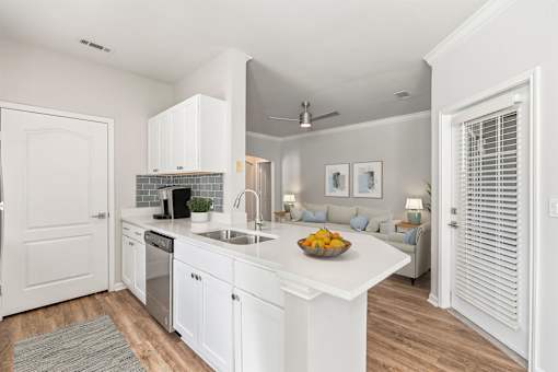 A kitchen with white cabinets and a bowl of fruit on the counter at Sweetgrass Landing, Mount Pleasant, SC