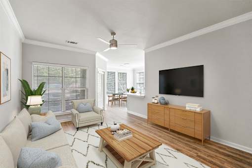 A living room with a white couch, a wooden coffee table, and a flat-screen TV mounted on the wall at Sweetgrass Landing, Mount Pleasant, South Carolina