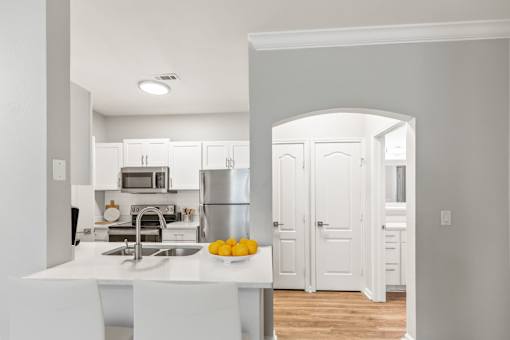 A kitchen with white cabinets and a white island with a bowl of lemons on it at Sweetgrass Landing, Mount Pleasant, SC