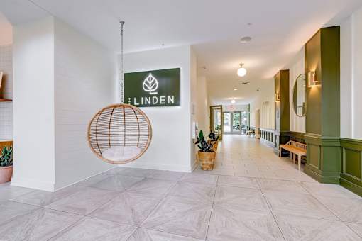 A hallway with a hanging chair and a sign that says Linden at The Linden Apartments, Davidson, NC