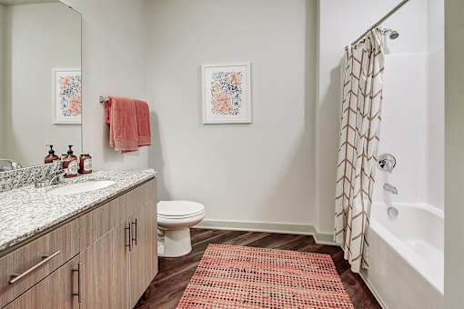 A bathroom with a toilet, sink, and shower at The Linden Apartments, North Carolina 28036