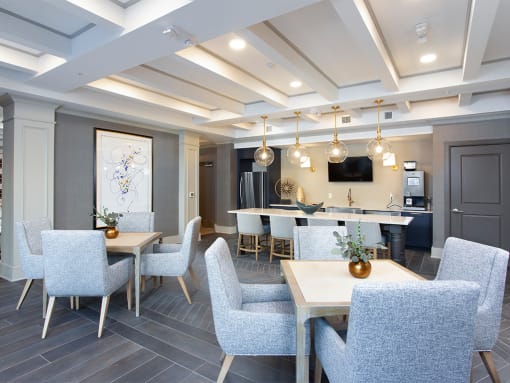 Community lounge with tables and chairs at St Mary's Square North Apartments, Raleigh, NC