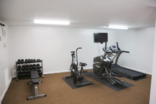 a room with two exercise bikes and a tv