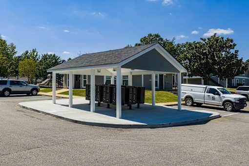 A small building with a parking lot in front.