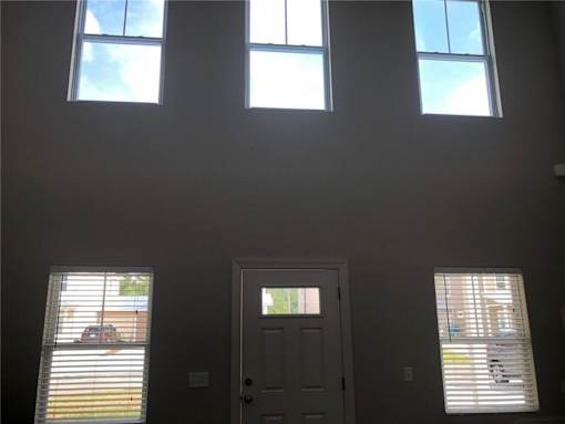 A room with a door, two windows and a ceiling light.