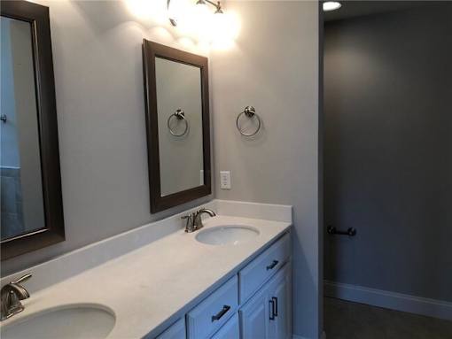 A bathroom with a sink, mirror, and light switch.