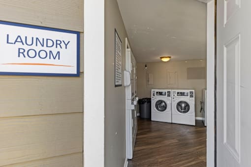 A laundry room with a sign on the wall.
