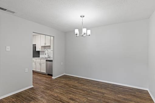 A kitchen with white walls and wooden floors is visible through a window.