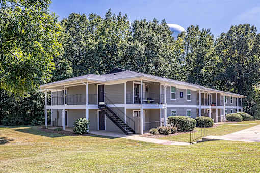 A large apartment complex with a green lawn in front.