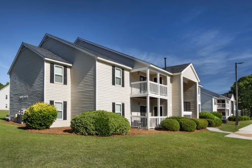 exterior view of three story residence with balconies and green grass