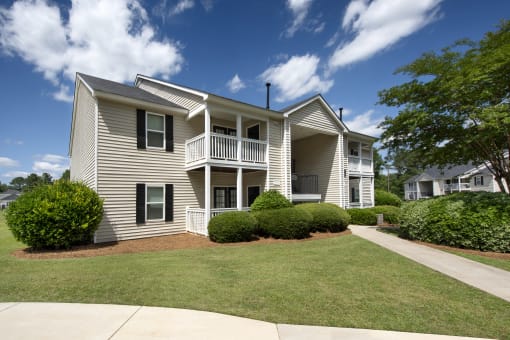 the view of an apartment building with a lawn and trees