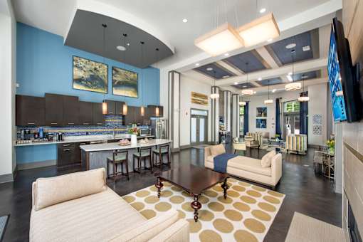 A modern living room with a kitchen area in the background.