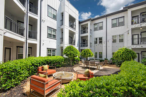 A white apartment building with a patio and a fire pit.