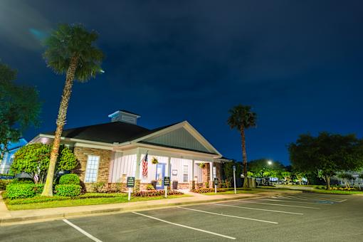 A building with a flag on it is lit up at night.